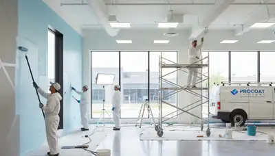 Commercial painting crew in Baltimore, MD applying durable exterior coating on a commercial building